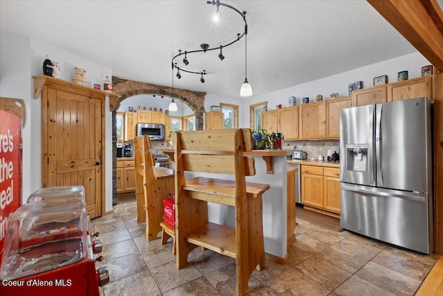 9670 N Meadow Way, Hayden, ID 83835 - kitchen with stainless steel appliances, backsplash, light countertops, pendant lighting, and a center island