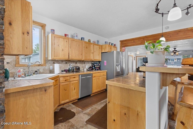 9670 N Meadow Way, Hayden, ID 83835 - kitchen featuring appliances with stainless steel finishes, a sink, tasteful backsplash, and tile counters