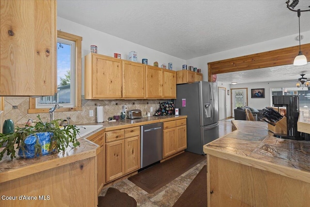 9670 N Meadow Way, Hayden, ID 83835 - kitchen with stainless steel appliances, a textured ceiling, decorative backsplash, open floor plan, and decorative light fixtures