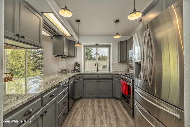 8846 N Clarkview Pl, Hayden, ID 83835 - kitchen featuring stainless steel appliances, gray cabinetry, dark wood-style flooring, backsplash, and light stone countertops
