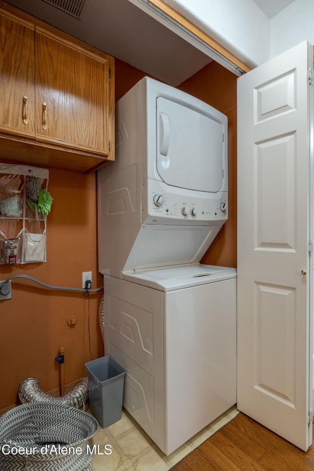 8846 N Clarkview Pl, Hayden, ID 83835 - washroom featuring stacked washer and clothes dryer and light wood-style flooring