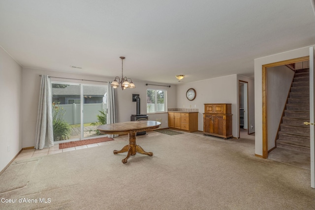 8846 N Clarkview Pl, Hayden, ID 83835 - dining area with a wood stove, stairs, light carpet, and a chandelier