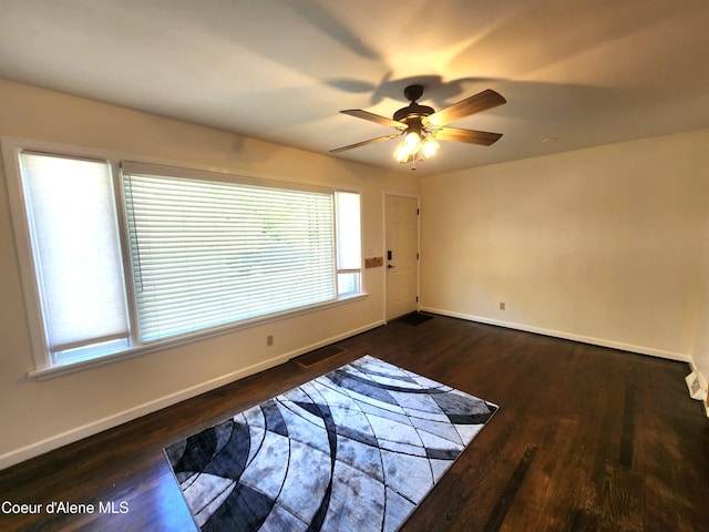 607 W Riverside Ave, Kellogg, ID 83837 - empty room featuring plenty of natural light, baseboards, ceiling fan, and dark wood-style floors