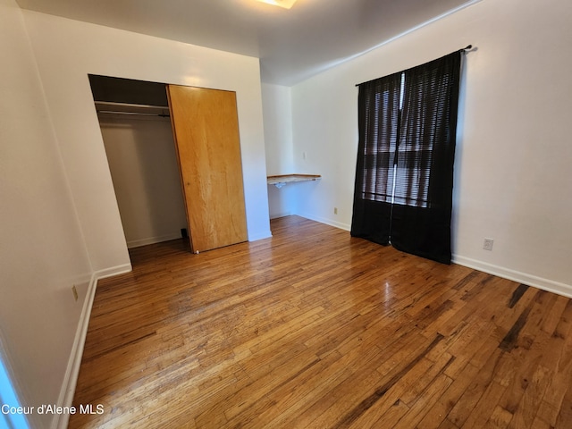 607 W Riverside Ave, Kellogg, ID 83837 - unfurnished bedroom featuring wood-type flooring, a closet, and baseboards