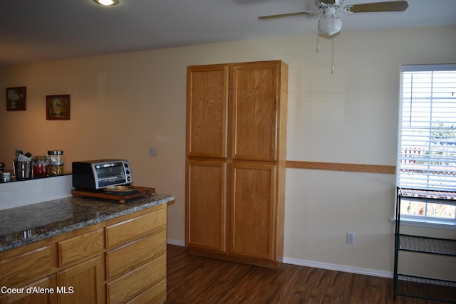 1406 Walnut, Sandpoint, ID 83864 - kitchen featuring dark wood-type flooring, ceiling fan, brown cabinetry, dark stone counters, and baseboards