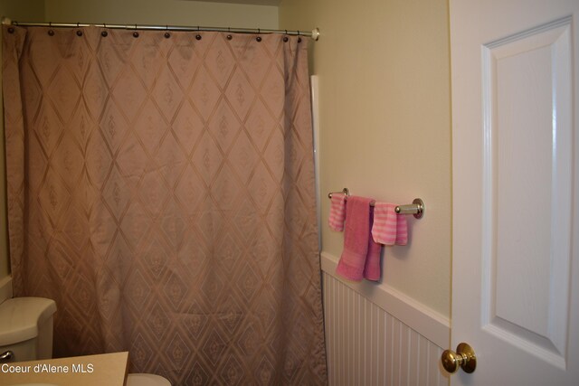 1406 Walnut, Sandpoint, ID 83864 - full bathroom with toilet, wainscoting, a decorative wall, vanity, and a shower with shower curtain