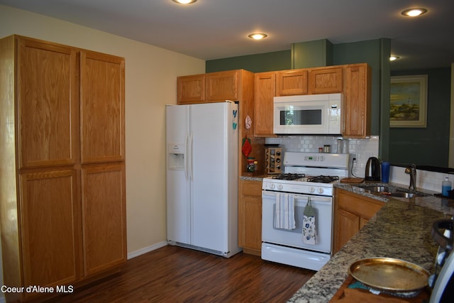 1406 Walnut, Sandpoint, ID 83864 - kitchen featuring white appliances, a sink, dark wood-type flooring, decorative backsplash, and dark stone counters