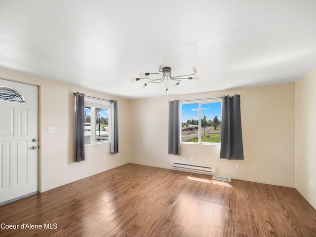 409 N 2nd St, Fairfield, WA 99012 - unfurnished living room with a baseboard radiator, wood finished floors, and a chandelier