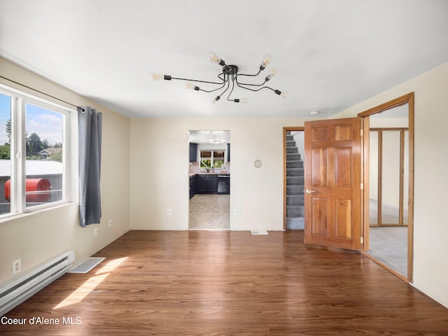 409 N 2nd St, Fairfield, WA 99012 - unfurnished living room featuring a baseboard radiator, a chandelier, stairway, and wood finished floors