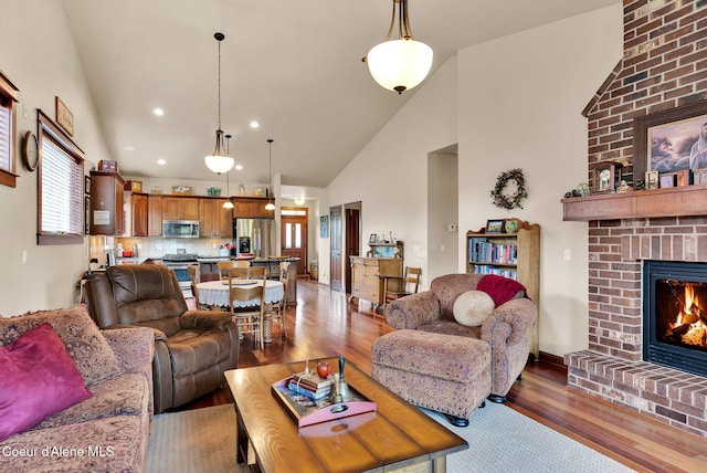14774 N Pristine Cir, Rathdrum, ID 83858 - living room featuring light wood-style flooring, a brick fireplace, high vaulted ceiling, and recessed lighting