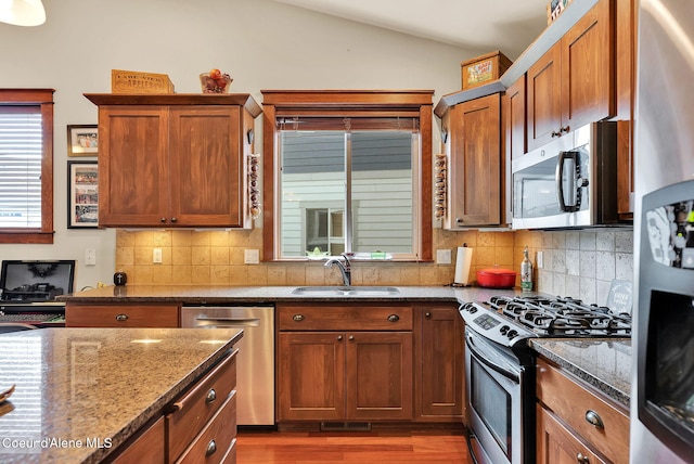 14774 N Pristine Cir, Rathdrum, ID 83858 - kitchen with appliances with stainless steel finishes, a sink, vaulted ceiling, wood finished floors, and dark stone counters