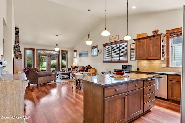14774 N Pristine Cir, Rathdrum, ID 83858 - kitchen with stainless steel dishwasher, open floor plan, light wood-type flooring, pendant lighting, and high vaulted ceiling