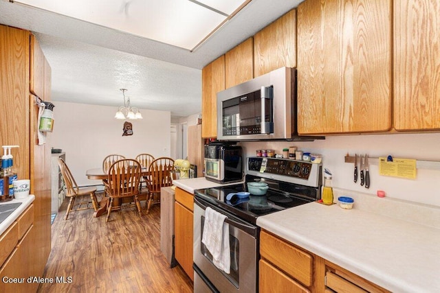 201 S Sequoia Ct, Post Falls, ID 83854 - kitchen with stainless steel appliances, a chandelier, light wood-type flooring, light countertops, and pendant lighting