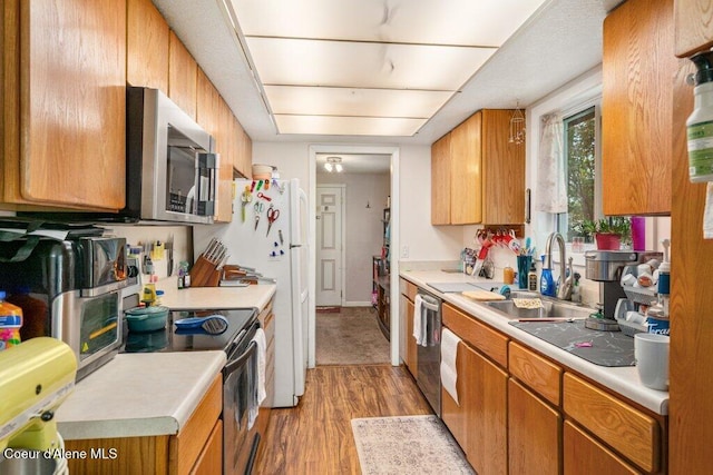 201 S Sequoia Ct, Post Falls, ID 83854 - kitchen with appliances with stainless steel finishes, a sink, light wood-style floors, light countertops, and brown cabinets