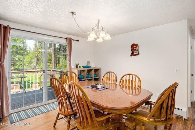 201 S Sequoia Ct, Post Falls, ID 83854 - dining space with wood finished floors, a chandelier, a textured ceiling, and baseboard heating