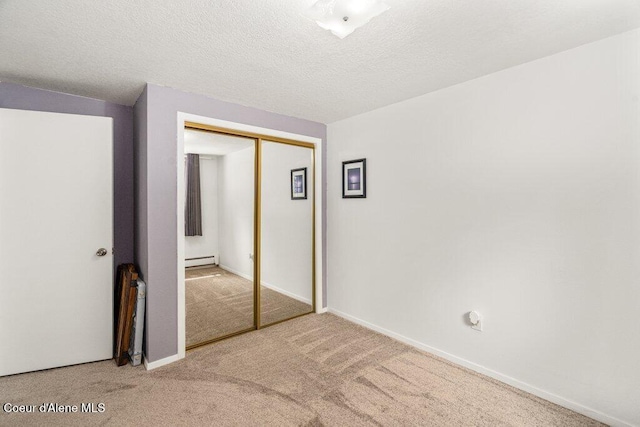 201 S Sequoia Ct, Post Falls, ID 83854 - unfurnished bedroom featuring carpet flooring, a closet, a baseboard heating unit, baseboards, and a textured ceiling