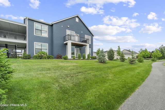 6430 N Atlas Rd Unit 101, Coeur Dalene, ID 83815 - rear view of property featuring a balcony and a lawn