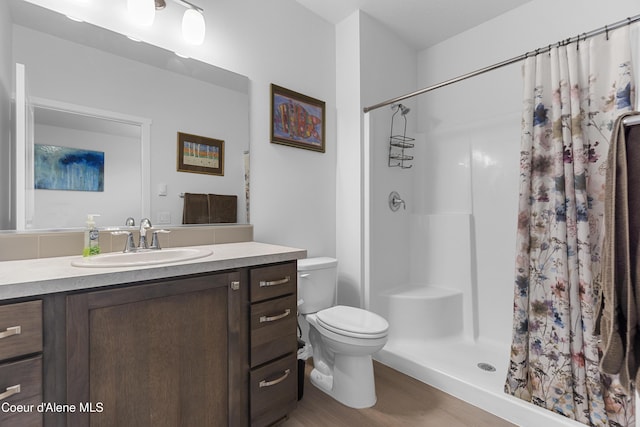 6430 N Atlas Rd Unit 101, Coeur Dalene, ID 83815 - bathroom with vanity, toilet, wood finished floors, and a shower with shower curtain