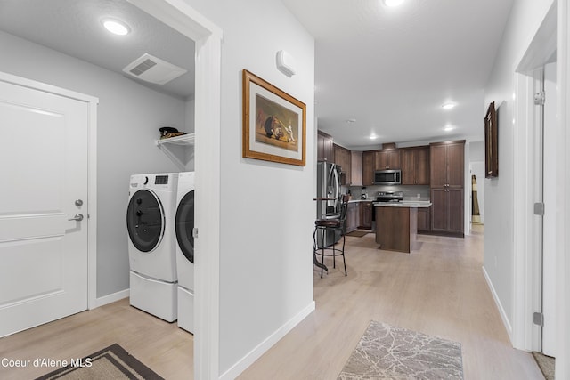 6430 N Atlas Rd Unit 101, Coeur Dalene, ID 83815 - laundry room with washer and dryer, light wood-type flooring, recessed lighting, and baseboards