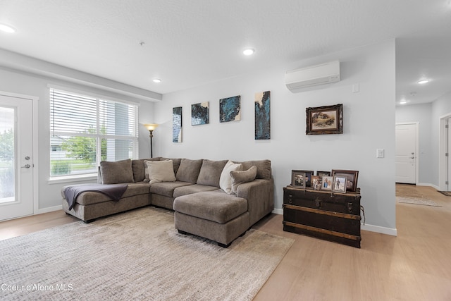 6430 N Atlas Rd Unit 101, Coeur Dalene, ID 83815 - living room featuring a wall mounted air conditioner, light wood finished floors, recessed lighting, and baseboards
