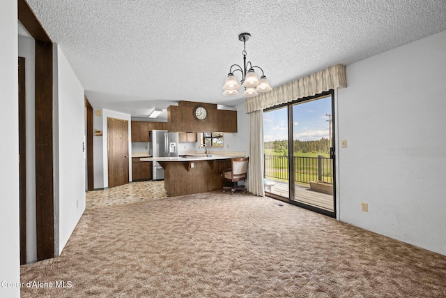 1995 Long Rd, Plummer, ID 83851 - kitchen with light countertops, a chandelier, a peninsula, a breakfast bar area, and light colored carpet