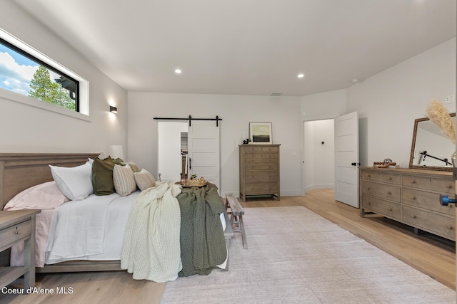 11733 N Blue Jay Loop, Hayden, ID 83835 - bedroom featuring a barn door, light wood finished floors, and recessed lighting