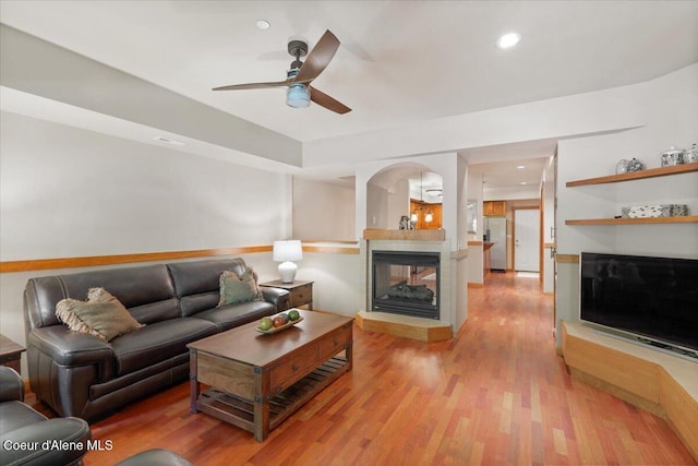 303 S 11th St, Coeur Dalene, ID 83814 - living room with a multi sided fireplace, ceiling fan, light wood-style flooring, arched walkways, and recessed lighting