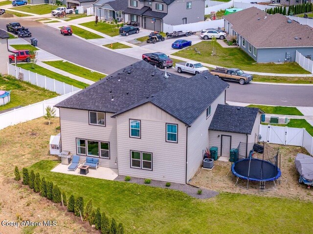 16171 N Hadley Loop, Rathdrum, ID 83858 - back of property with a trampoline, roof with shingles, a gate, a residential view, and board and batten siding