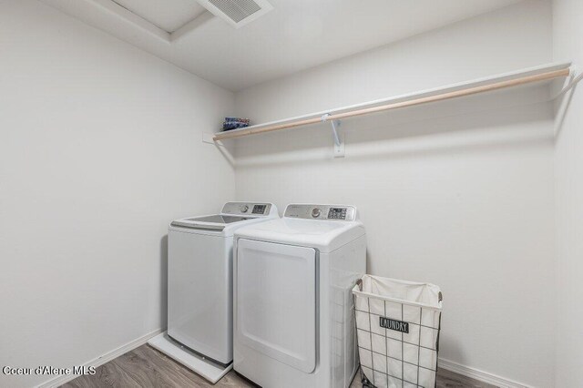 16171 N Hadley Loop, Rathdrum, ID 83858 - washroom featuring washing machine and dryer, baseboards, and wood finished floors
