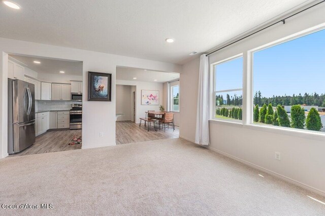 16171 N Hadley Loop, Rathdrum, ID 83858 - kitchen featuring stainless steel appliances, light carpet, recessed lighting, baseboards, and tasteful backsplash
