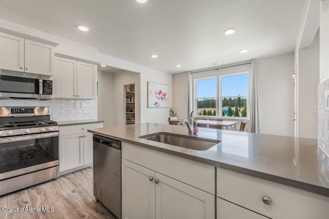 16171 N Hadley Loop, Rathdrum, ID 83858 - kitchen with stainless steel appliances, a sink, white cabinetry, light wood-style flooring, and recessed lighting