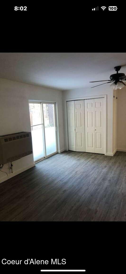 243 Pine St, Moyie Springs, ID 83845 - unfurnished bedroom with heating unit, wood finished floors, access to outside, baseboards, and a closet