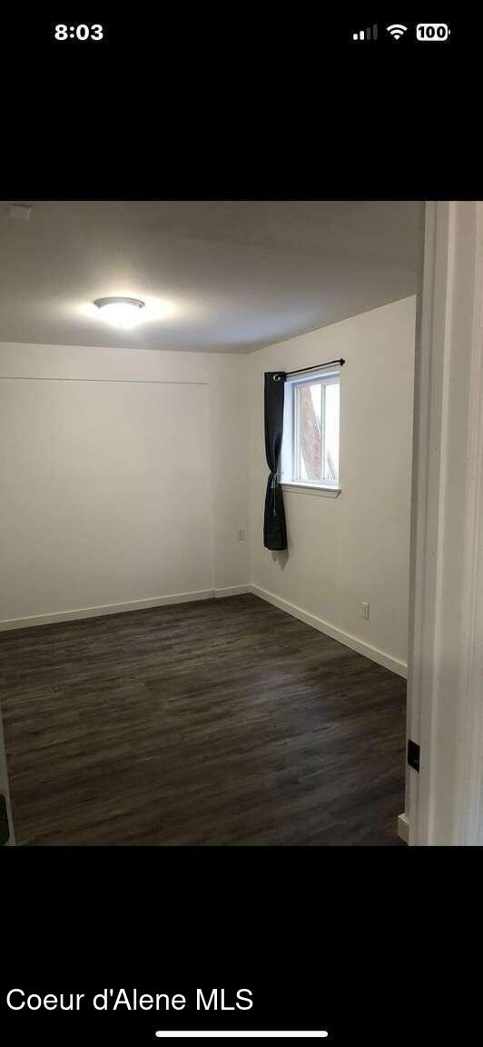 243 Pine St, Moyie Springs, ID 83845 - empty room with dark wood-style flooring and baseboards