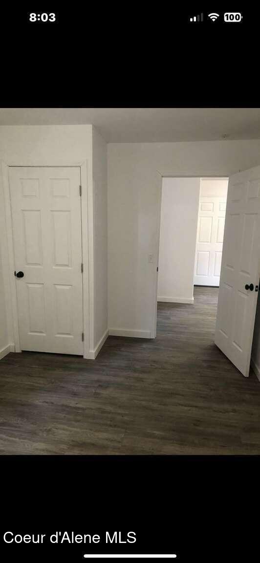 243 Pine St, Moyie Springs, ID 83845 - hallway with baseboards and dark wood-style flooring
