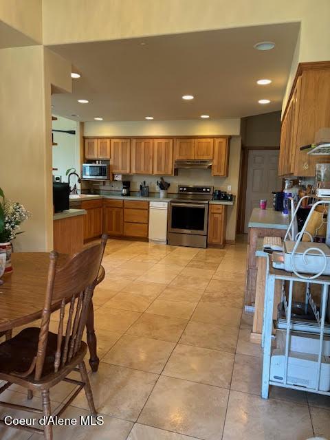 707 Patches Ln, Saint Maries, ID 83861 - kitchen featuring stainless steel appliances, under cabinet range hood, recessed lighting, light countertops, and brown cabinets