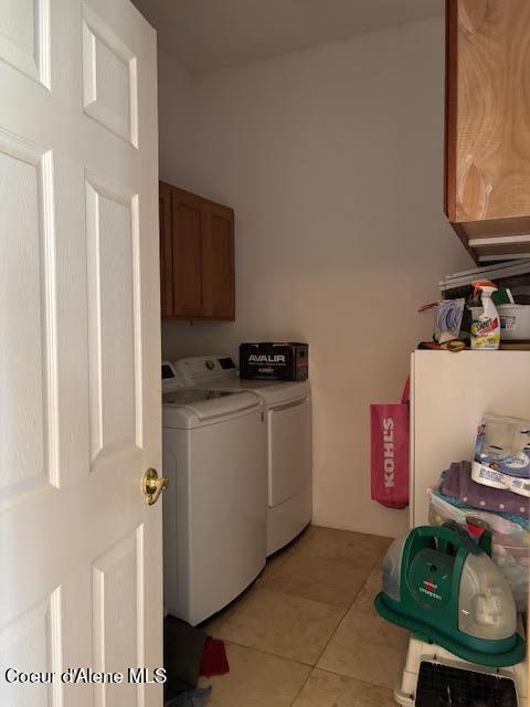 707 Patches Ln, Saint Maries, ID 83861 - laundry room with washing machine and clothes dryer, cabinet space, and light tile patterned flooring