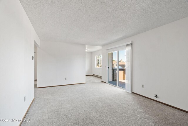 107 E Hattie Ave, Coeur Dalene, ID 83814 - empty room featuring light carpet, a textured ceiling, and baseboard heating