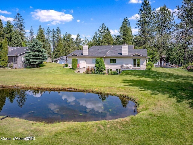 21013 N Circle Rd, Rathdrum, ID 83858 - back of house featuring a yard, a chimney, and a water view