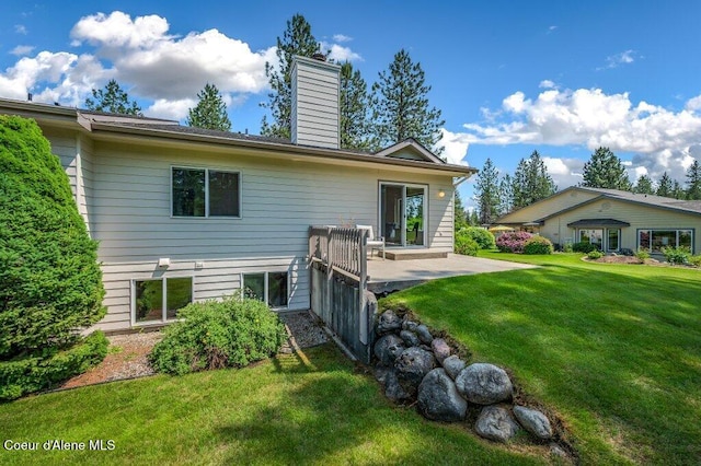 21013 N Circle Rd, Rathdrum, ID 83858 - back of property with a lawn, a patio area, and a chimney