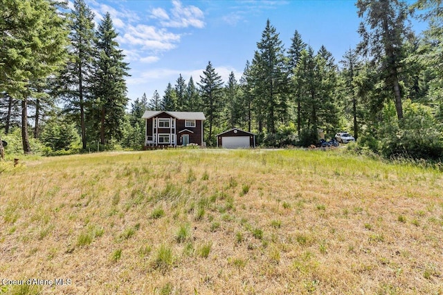 596 Overlake View Rd, Cocolalla, ID 83813 - view of yard with a garage, an outdoor structure, and a view of trees