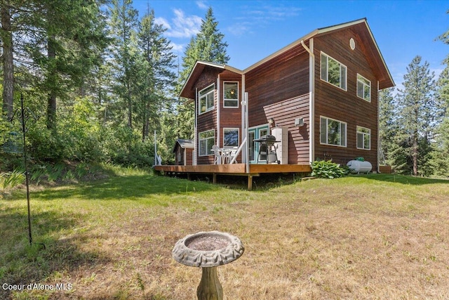 596 Overlake View Rd, Cocolalla, ID 83813 - rear view of house with a wooden deck, a lawn, and an outdoor fire pit
