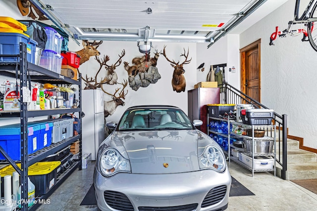 3857 E Beckon Ridge Rd, Coeur Dalene, ID 83814 - garage featuring a garage door opener, freestanding refrigerator, and a textured wall