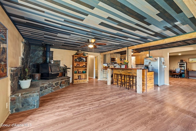 312 E 5th Ave, Clark Fork, ID 83811 - living room with a wood stove, light wood-style floors, and a ceiling fan