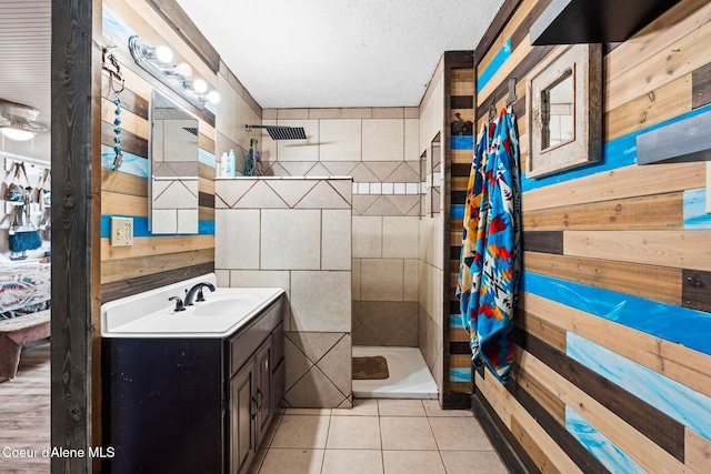 312 E 5th Ave, Clark Fork, ID 83811 - bathroom featuring wooden walls, a stall shower, vanity, tile patterned floors, and a textured ceiling