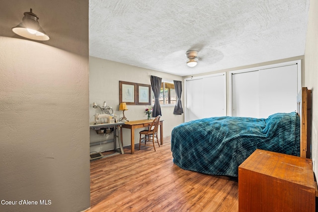 312 E 5th Ave, Clark Fork, ID 83811 - bedroom featuring two closets, wood finished floors, a textured ceiling, and ceiling fan