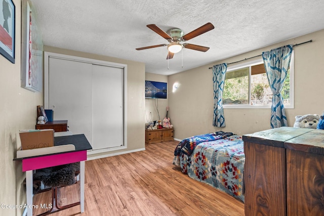 312 E 5th Ave, Clark Fork, ID 83811 - bedroom featuring wood finished floors, a textured ceiling, a closet, and ceiling fan