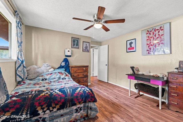312 E 5th Ave, Clark Fork, ID 83811 - bedroom with wood finished floors, a textured ceiling, and a ceiling fan