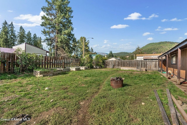 312 E 5th Ave, Clark Fork, ID 83811 - fenced backyard featuring a garden and a mountain view