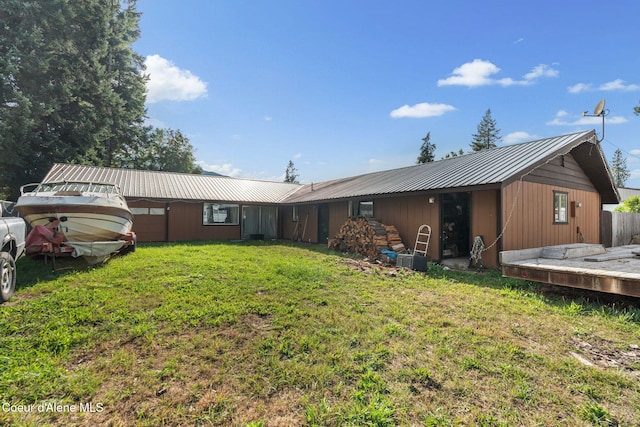 312 E 5th Ave, Clark Fork, ID 83811 - back of house featuring a metal roof, a lawn, and an attached garage