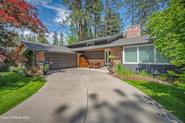 3593 W Fairway Dr, Coeur Dalene, ID 83815 - view of front facade with brick siding, a chimney, a front lawn, concrete driveway, and a garage